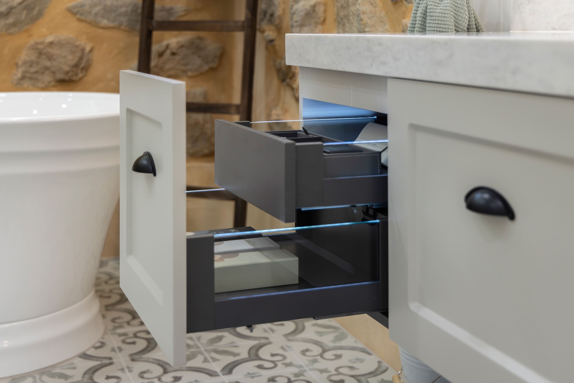 Hamptons Style Cabinetry with Carrera Looking Benchtops, Wall-Hung Vanity with Illuminated Insert Drawers, White Shaker Profiles and Classic Handles in Black