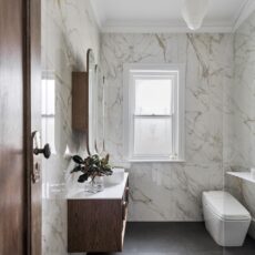 Luxurious Art-Deco Bathroom. Floor-to-ceiling marble-like tiles.