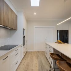 renovated kitchen open plan design with bespoke joinery, kitchen island with functional storage, ceiling skylight, induction cooktop