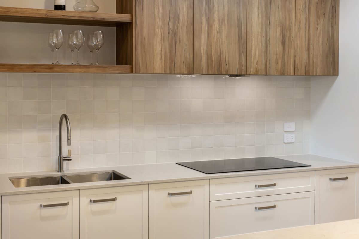 Kitchen renovation in Paradise SA featuring small square tiled splashback, engineered benchtops, double-bowl sink and bespoke joinery in timber and white tones