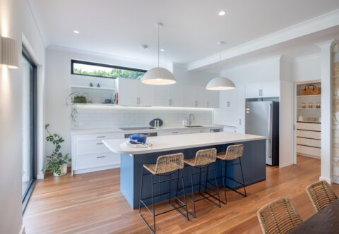 renovated open-plan kitchen with featured blue island, porcelain benchtops and solid timber flooring, contemporary, bright and functional