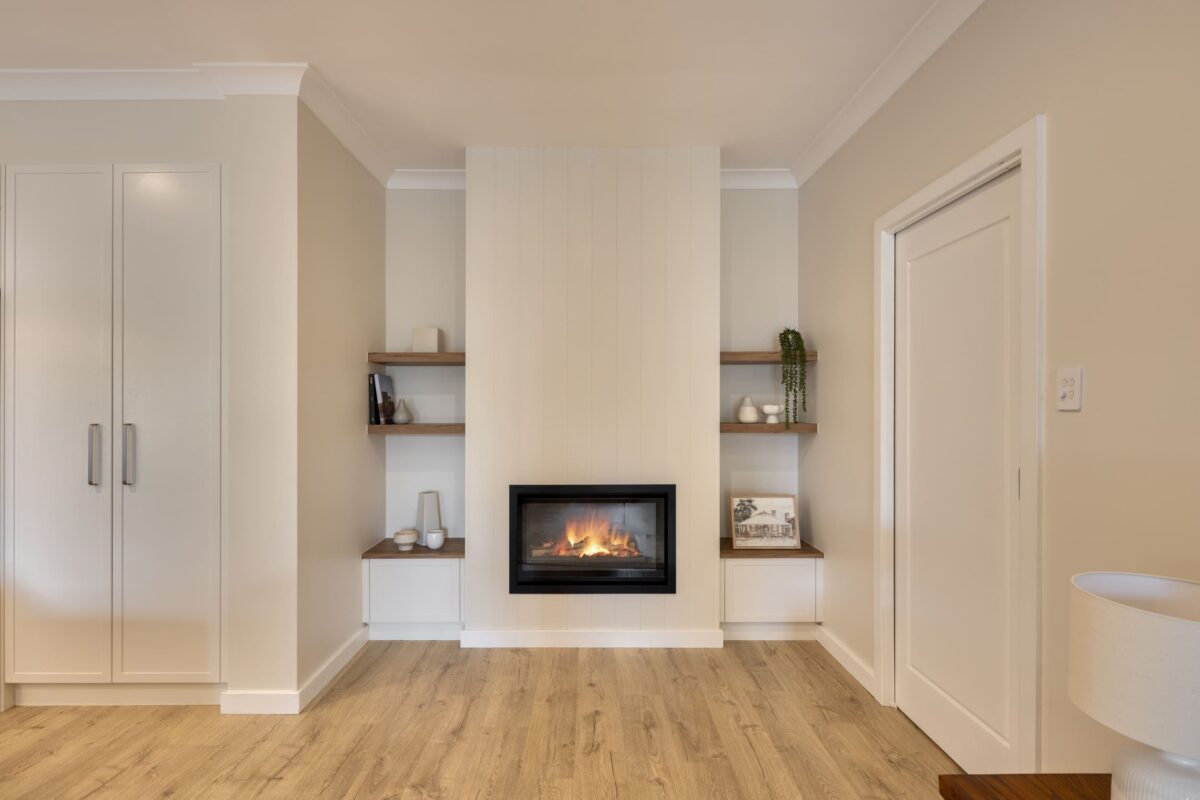 renovated living room, VJ panelling with gas fireplace, custom cabinetry and floating shelves.