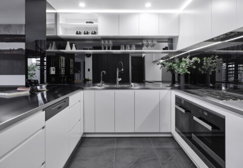 renovated kitchen, stainless steel benchtops and mirror splashback, breakfast bar, bespoke joinery with built-in appliances