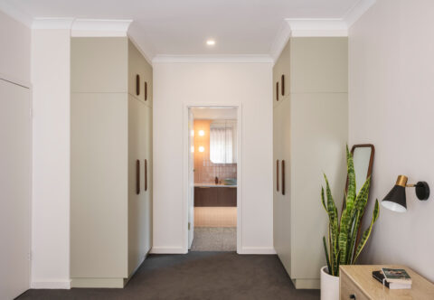 renovated wardrobe with retro style, in eucalyptus green tones paired with timber handles