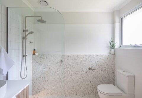 renovated bathroom, walk-in shower, curved glass divider with terrazzo wall tiles on shower ledge, and feature kitkat tiles, finished with chrome tapware