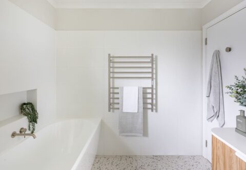 renovated bathroom, back-to-wall bathtub, heated towel rails, terrazzo floor tiles and chrome tapware