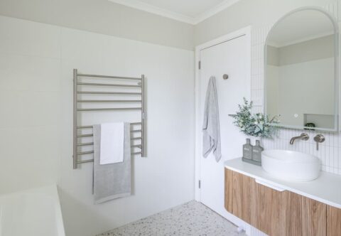 renovated bathroom, heated towel rails, terrazzo floor tiles, wall-hung vanity and curved mirror cabinet.