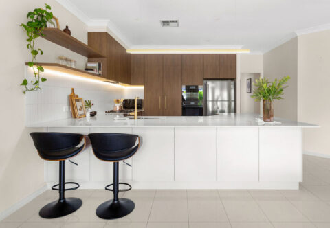 renovated kitchen, contemporary style with bespoke cabinetry in walnut tones paired with brushed brass tapware, large breakfast bar, open shelved and tiled flooring
