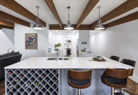 renovated kitchen, bespoke joinery with wine rack on kitchen island, breakfast bar, chrome tapware and engineered stone
