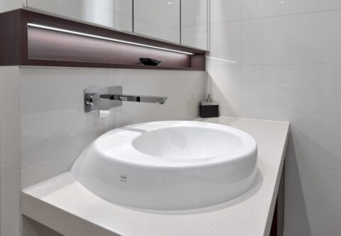 renovated bathroom, his and hers vanities with floating vessels on solid surface benchtops, recessed mirror cabinets, LED strip lights