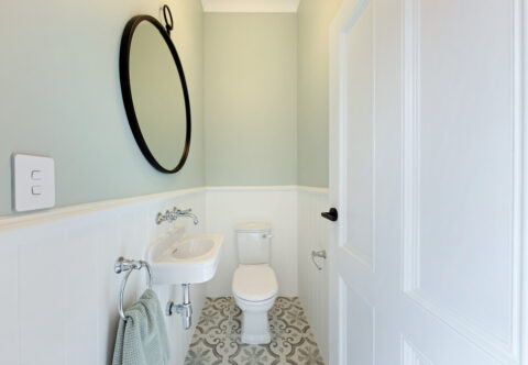 renovated bathroom, traditional country style, VJ panelling, patterned porcelain floor tiles, sage painted walls, traditional tapware, compact and functional