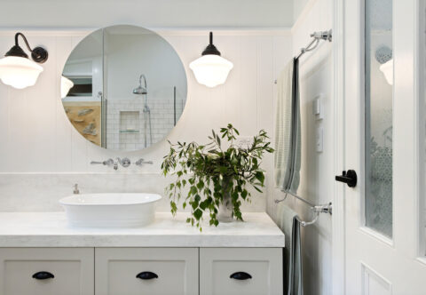 renovated bathroom, traditional country style, VJ panelling, patterned porcelain floor tiles, wall-hung vanity with marble-look benchtop, round mirror cabinet and black accents.