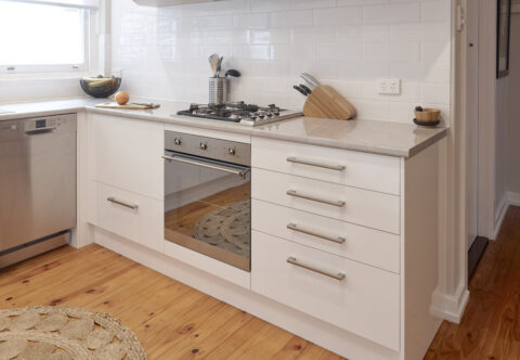 renovated kitchen bespoke joinery, stone tops and subway tiled splashback, stainless steel appliances, handles, wooden open shelves