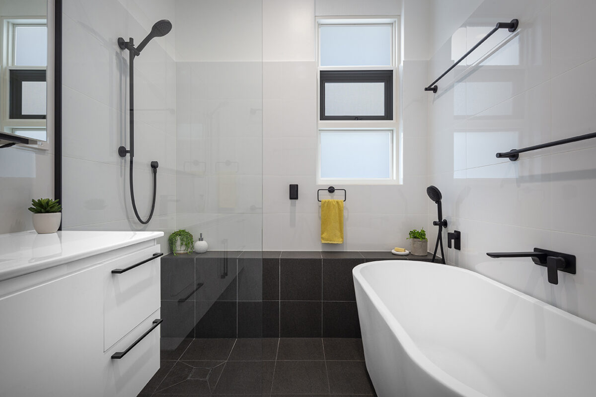renovated bathroom, monochromatic with free standing bathtub, shower bench seat and open walk-in shower.