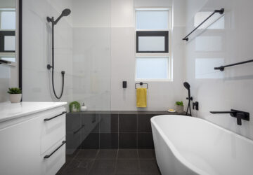 renovated bathroom, monochromatic with free standing bathtub, shower bench seat and open walk-in shower.