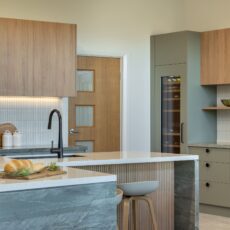 renovated kitchen, and living room of 1920s California Bungalow, beautiful green cabinetry paired with Tasmanian oak and solid surface acrylic benchtop.