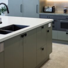 renovated kitchen, contemporary style, beautiful green cabinetry paired with white solid surface acrylic benchtop and black fixtures and fittings.