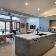 renovated kitchen, and living room in Cowandilla, designed and built by Brilliant SA Renovations, it features a with large kitchen island with Emerald Green Quartzite on island waterfall ends and solid surface acrylic benchtop.
