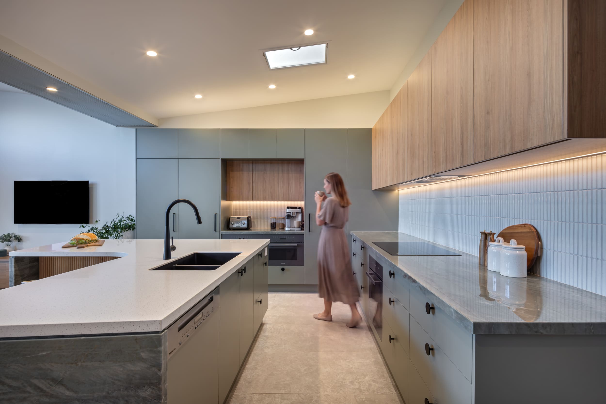 renovated kitchen, contemporary style, beautiful green cabinetry paired with Tasmanian oak and Emerald Green natural Quartzite benchtops and black fixtures and fittings