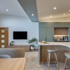 renovated kitchen, and living room of 1920s California Bungalow, beautiful green cabinetry paired with Tasmanian oak and solid surface acrylic benchtop.