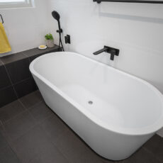 renovated bathroom, monochromatic with free standing bathtub, shower bench seat and open walk-in shower.