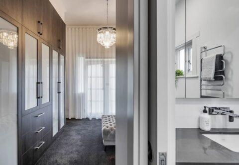renovated walk-in robe and ensuite, glam luxe style and WINNER for Master Suite SA+ TAS+WA at the KBDi Designer Awards 2020. Bespoke joinery using Woodmatt finish profiles, paired with translucent glass inserts, finished with a Crystal chandelier pendant for a glamourous look.