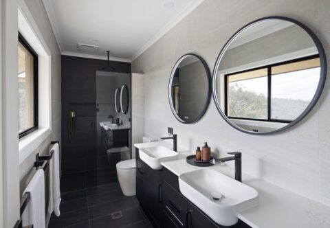 renovated bathroom, monochromatic and contemporary, black tapware, double vanity and walk-in shower with bench seat.