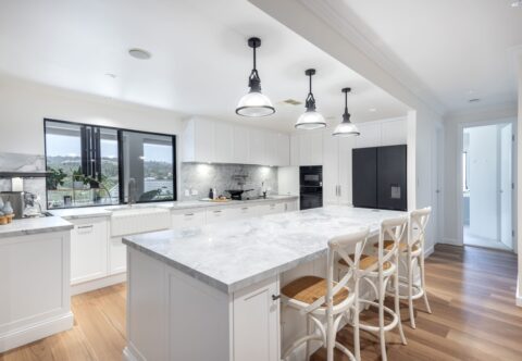 renovated kitchen with large kitchen island, ceramic benchtops, custom joinery and inbuilt appliances. Structural changes made by a licenced builder -Brilliant SA Renovations.