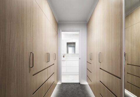 renovated walk-in robe with bespoke joinery in oak finish, LED floor lighting on both sides and grey plush carpet