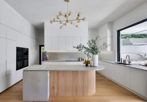 renovated kitchen, contemporary style with cascading benchtop and feature fluted breakfast bar, new wooden floor, open plan design.
