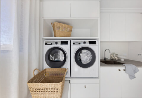 renovated laundry on full home renovation, contemporary style, lifted washer and dryer, pull out stand for laundry basket, custom joinery, laminated benchtops.