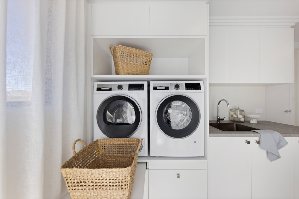renovated laundry on full home renovation, contemporary style, lifted washer and dryer, pull out stand for laundry basket, custom joinery, laminated benchtops.