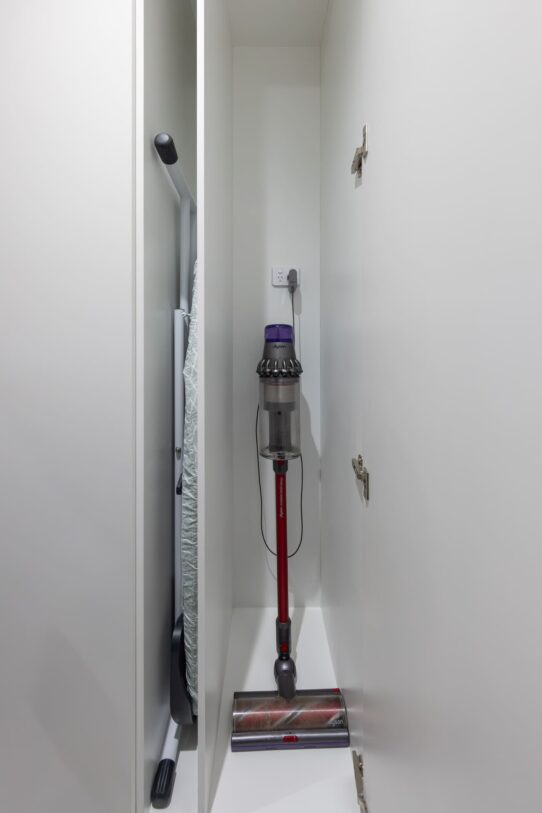 Renovated laundry room with a dedicated broom cabinet with a charging port for the vacuum