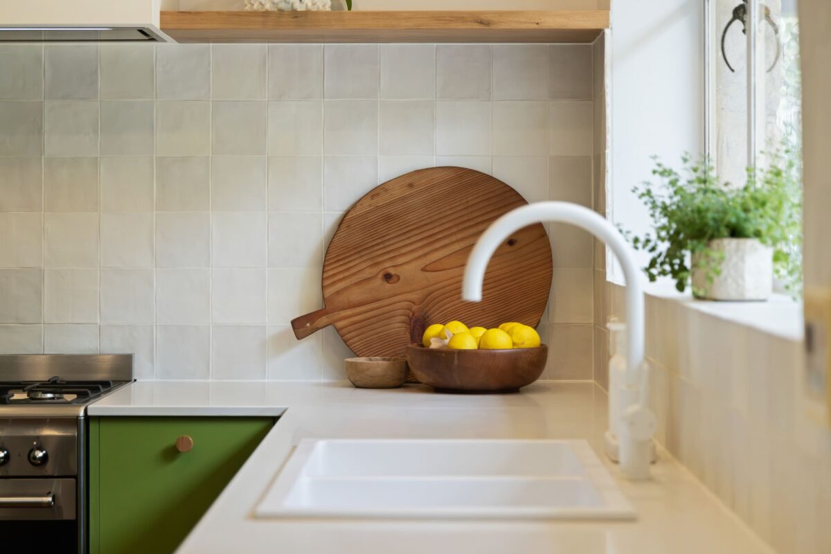 Renovated kitchen in Blackwood with retro-inspired style, vibrant green cabinetry, solid timber shelves and white benchtops.