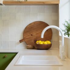 Renovated kitchen in Blackwood with retro-inspired style, vibrant green cabinetry, solid timber shelves and white benchtops.