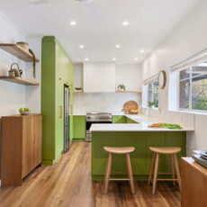 Renovated kitchen in Blackwood with retro-inspired style, vibrant green cabinetry, solid timber shelves and white benchtops.